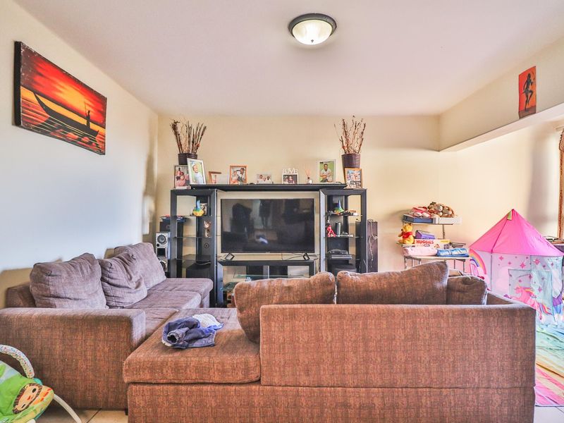 A comfortable living room area featuring neutral wall finishes and a central ceiling light fixture, providing a functional space for relaxation.
