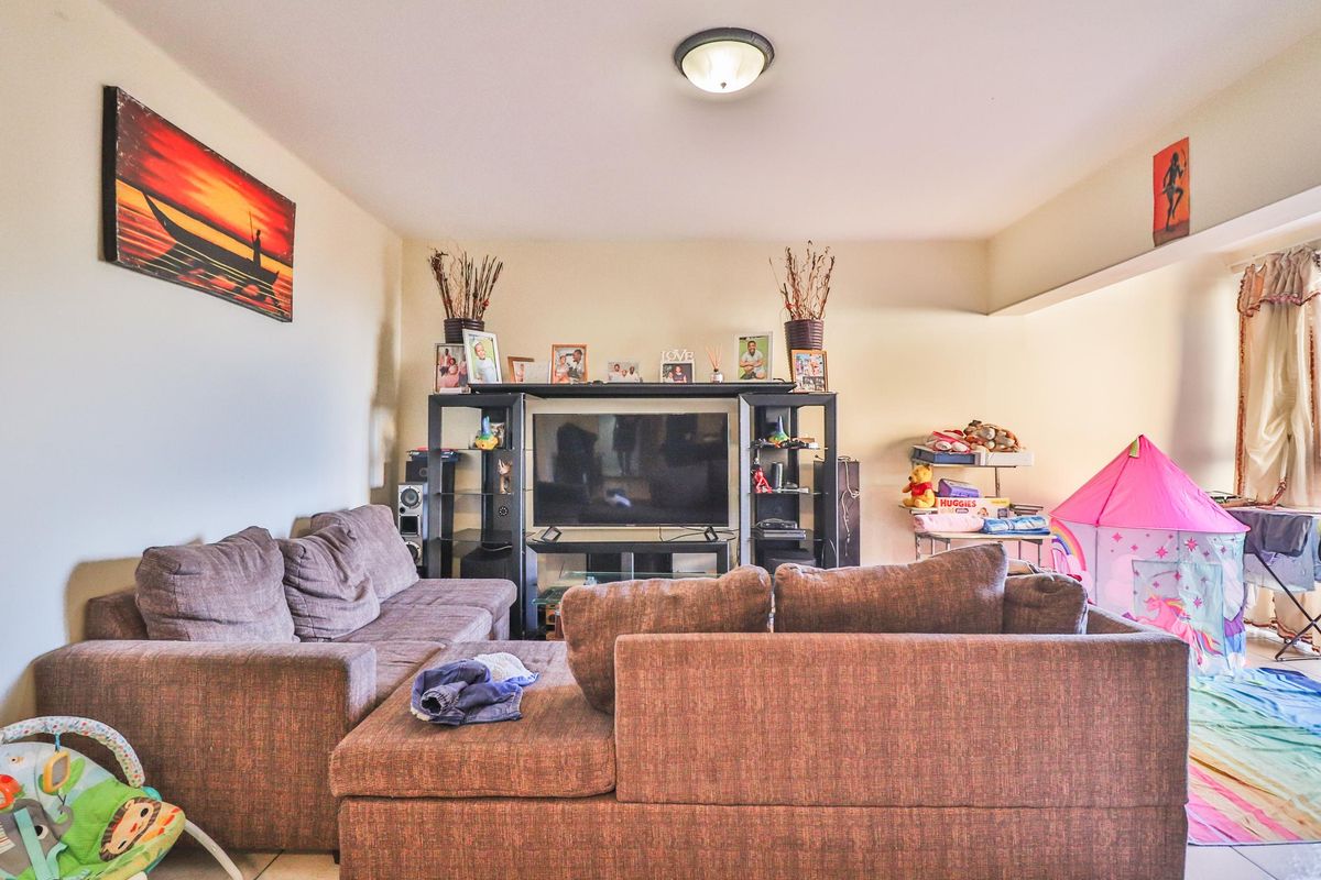 A comfortable living room area featuring neutral wall finishes and a central ceiling light fixture, providing a functional space for relaxation.