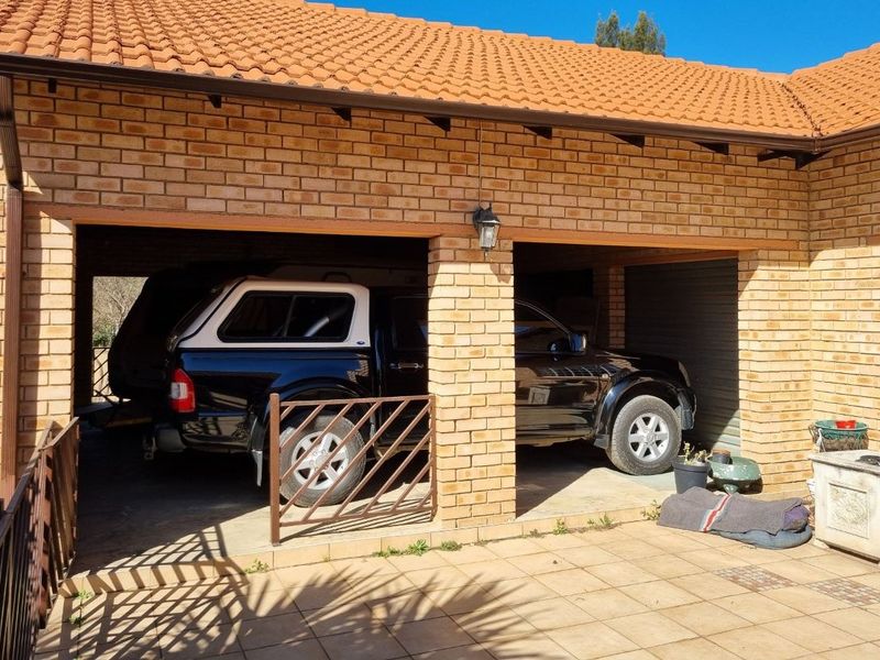 A double-bay open-fronted garage featuring face brick construction and a tiled roof, providing sheltered parking space.