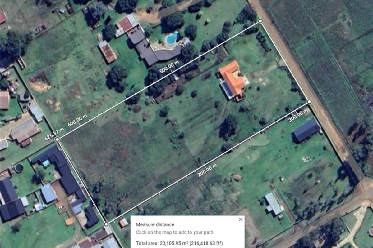 Aerial view of a large small holding property showing the main dwelling, outbuilding, and expansive grounds with boundary measurements.