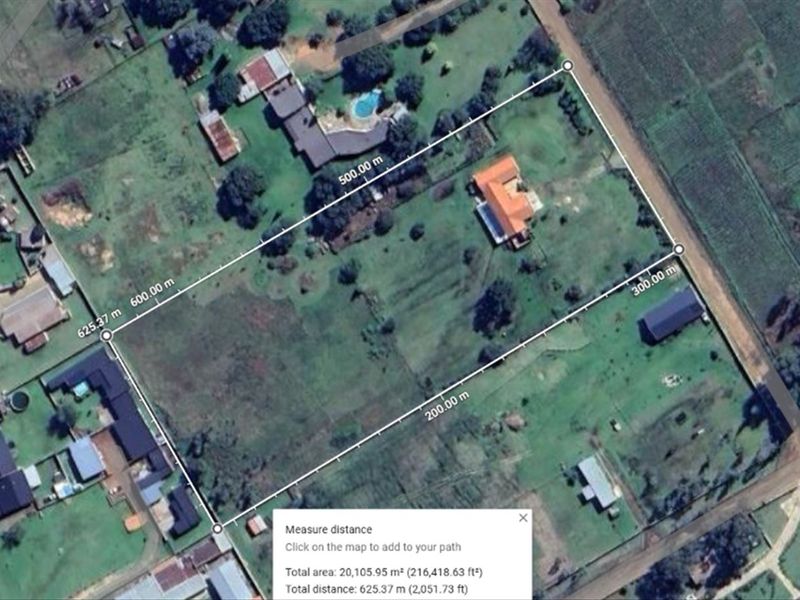 Aerial view of a large small holding property showing the main dwelling, outbuilding, and expansive grounds with boundary measurements.