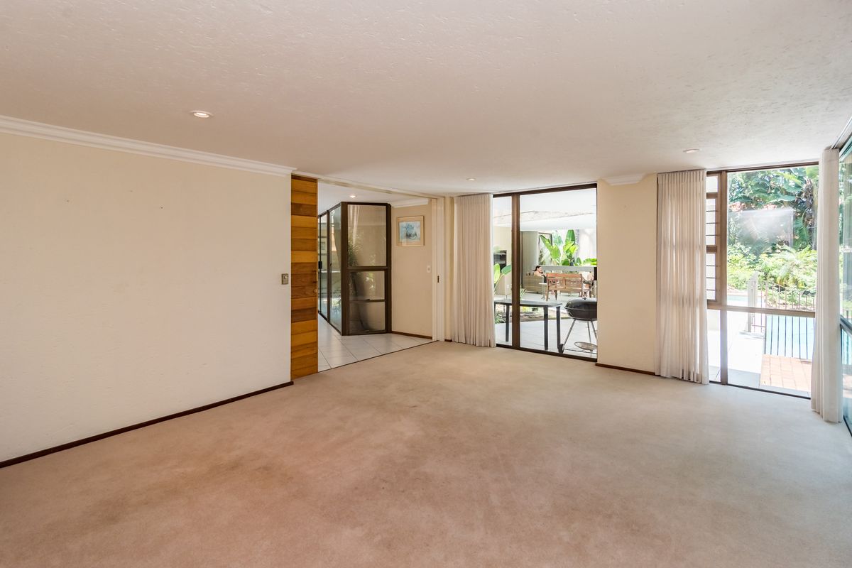 Spacious, light-filled living area featuring neutral carpeting, recessed lighting, and large sliding glass doors providing seamless access to the outdoor patio area.