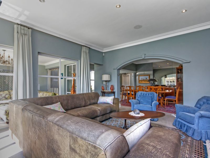 Spacious open-plan living and dining area featuring an elegant archway, recessed lighting, and large sliding glass doors leading to an adjacent patio space.