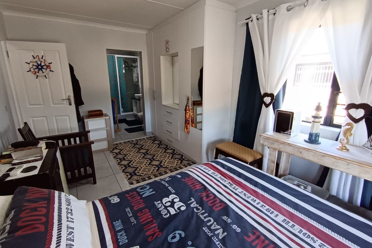 A bedroom featuring built-in cupboards, tiled flooring, and direct access to an en-suite bathroom.
