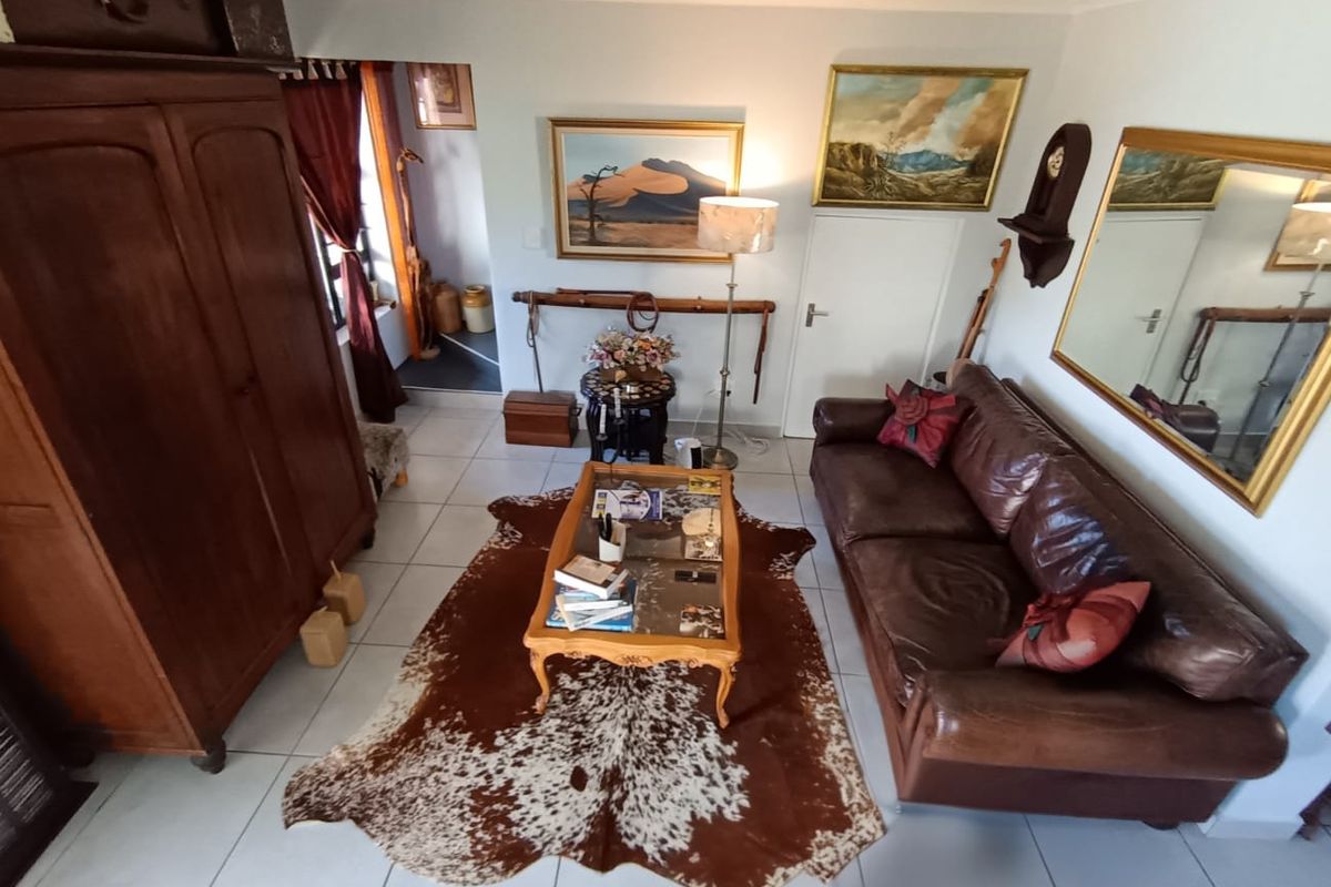 A living room featuring tiled flooring and coved ceilings, providing a functional space with neutral wall finishes.