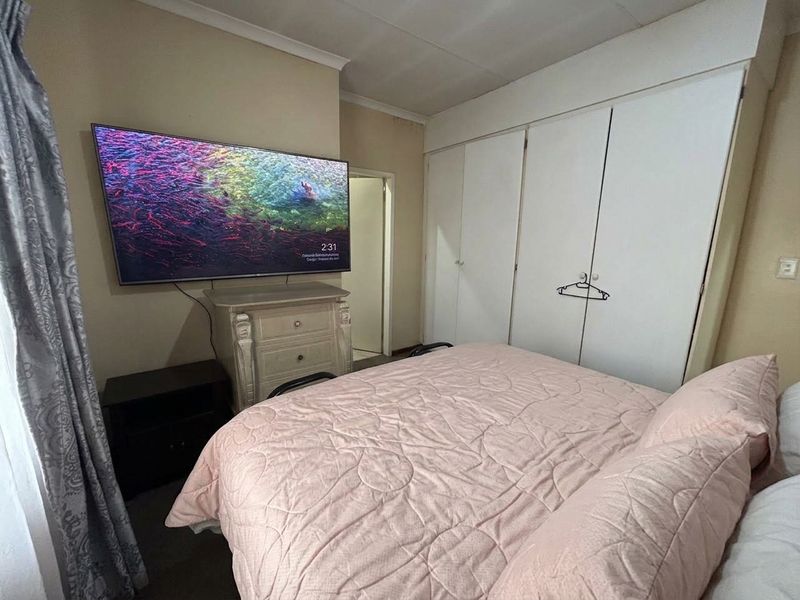 A functional bedroom featuring built-in cupboards and neutral wall finishes, providing a practical space for rest and storage.