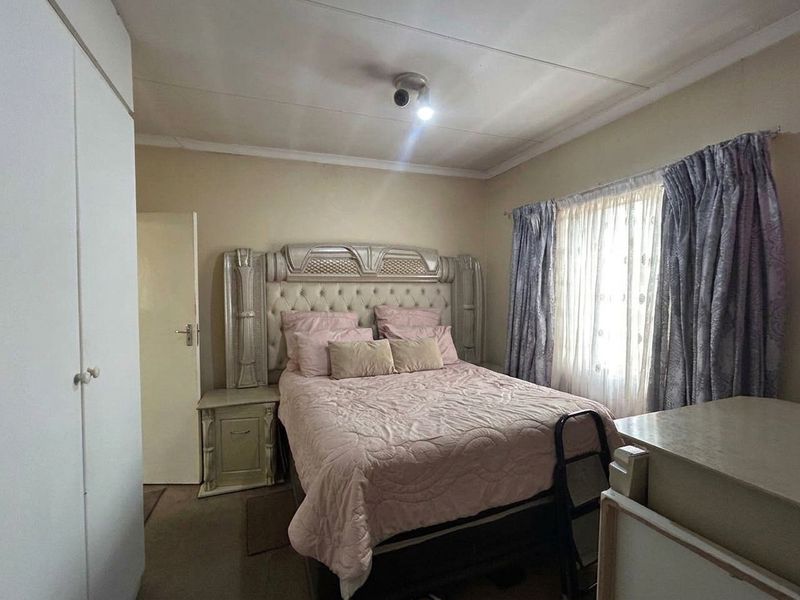 A standard bedroom featuring a built-in wardrobe and neutral wall finishes, offering a functional space ready for personal updates.