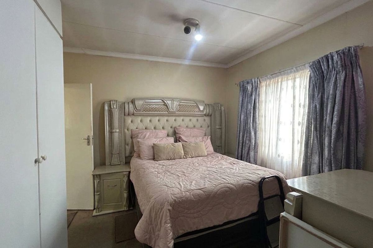 A standard bedroom featuring a built-in wardrobe and neutral wall finishes, offering a functional space ready for personal updates.