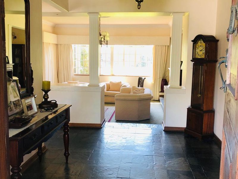 Welcoming entrance hall featuring dark slate flooring, decorative ceiling rose, and an open-plan transition into the adjacent living area.