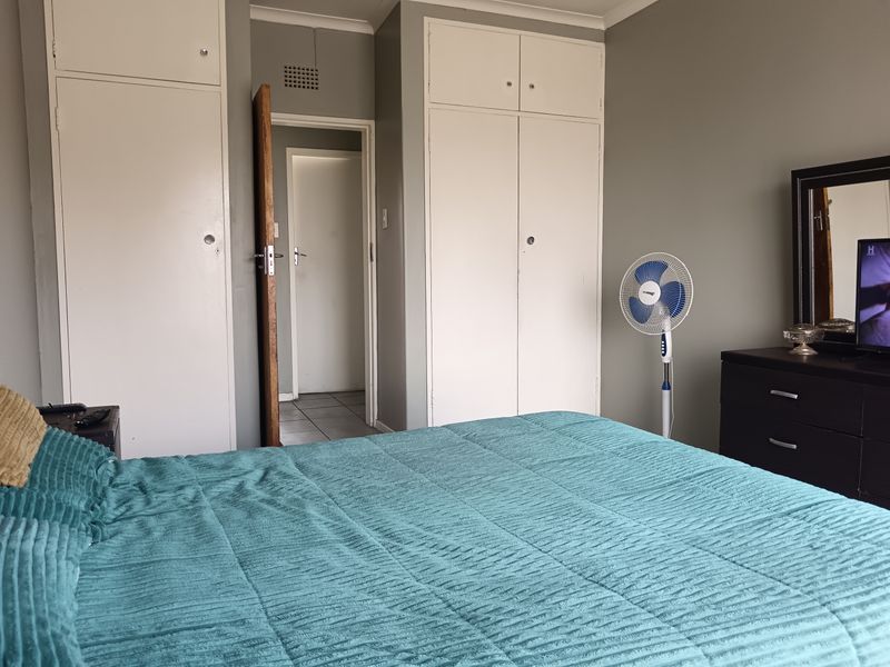 A bedroom featuring built-in cupboards and neutral wall tones, providing functional storage space within the apartment.