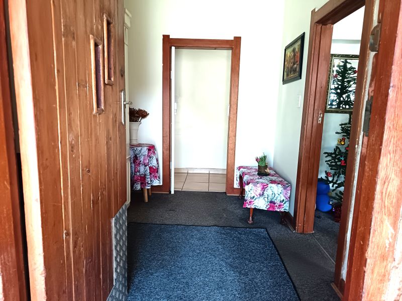 A functional entryway featuring wooden door frames and carpeted flooring, providing access to adjacent rooms within the home.