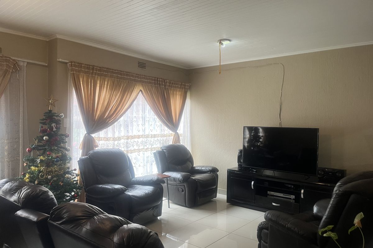A living room featuring tiled flooring and a tongue and groove ceiling, with visible electrical wiring requiring attention.