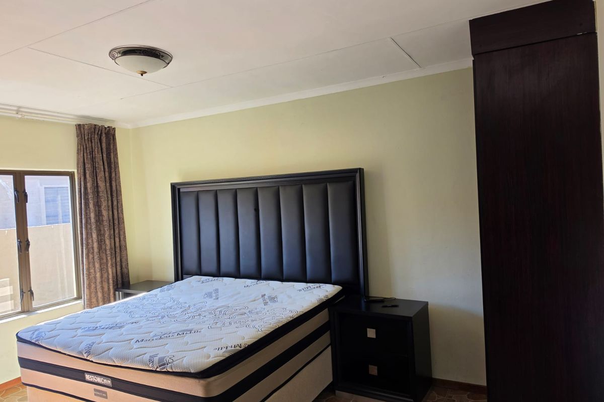 A bedroom featuring a built-in cupboard and tiled flooring, with visible ceiling panel damage requiring maintenance.