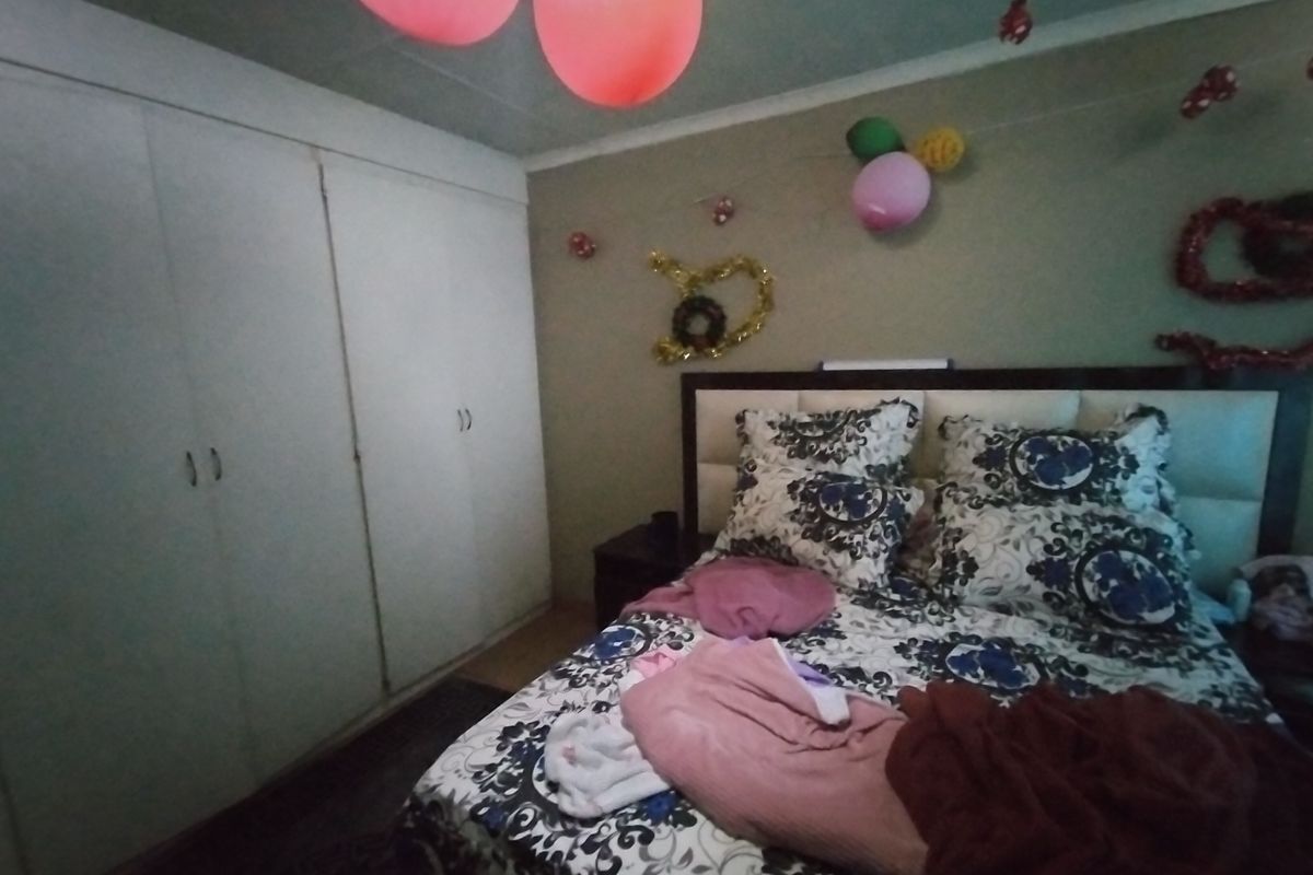 A bedroom featuring built-in cupboards and a double bed, providing functional storage and sleeping space.