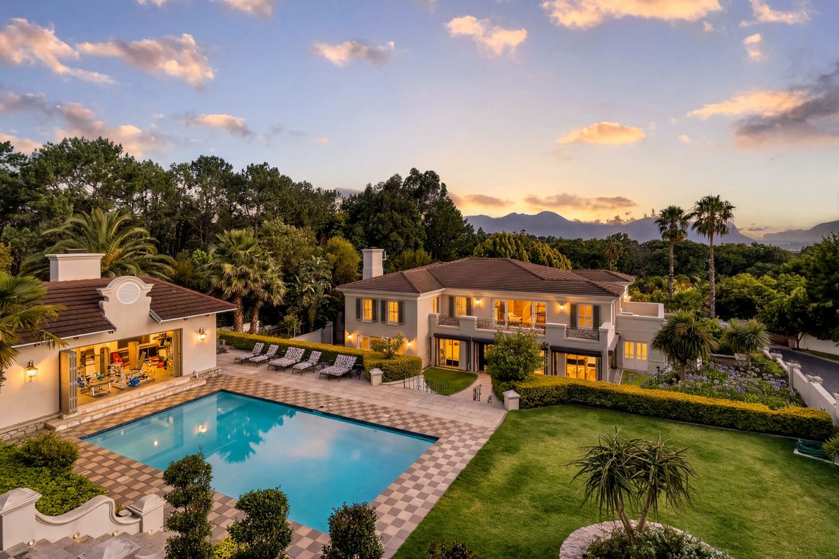 Stunning rear elevation featuring a swimming pool, manicured garden, and spacious balcony, set against a scenic mountain backdrop at sunset.