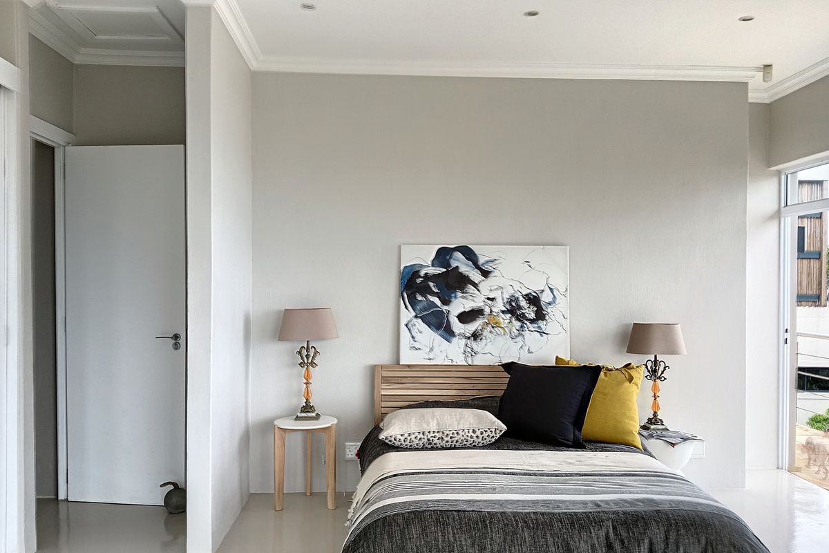 A bright and well-maintained bedroom featuring neutral walls, crown molding, recessed lighting, and a sliding glass door providing access to the exterior.