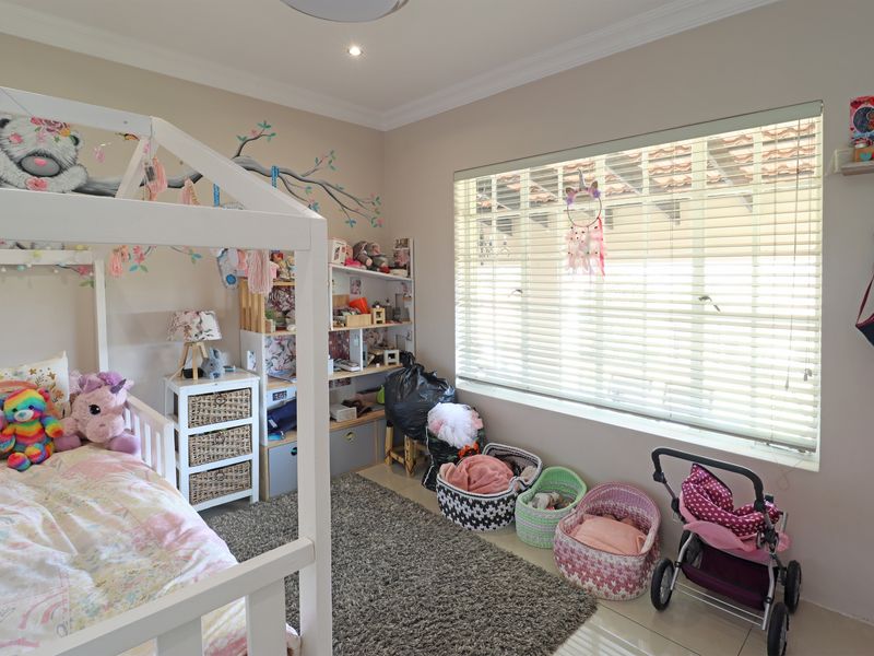 A well-maintained bedroom featuring tiled flooring, recessed downlighting, and venetian blinds, providing a functional and comfortable living space.
