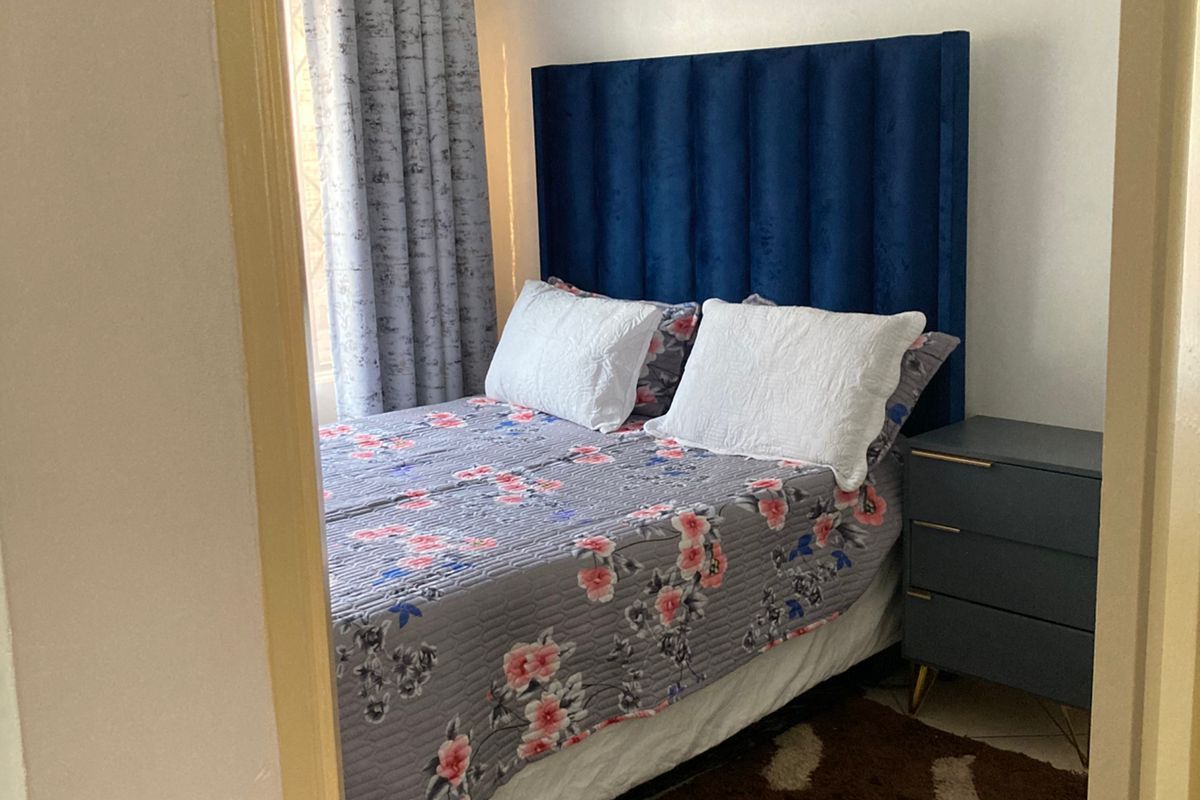 A cozy bedroom featuring tiled flooring and a view from the doorway.