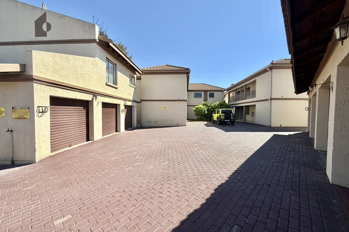 A paved courtyard area featuring multiple garage doors and access to the apartment complex buildings.