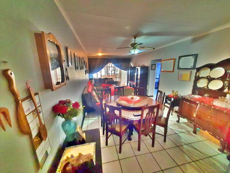 Open plan living and dining area featuring tiled flooring and a ceiling fan, providing a functional space for daily living.