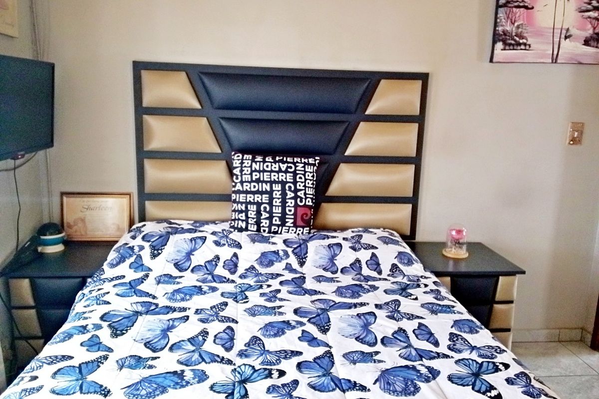 A bedroom featuring a built-in headboard and matching bedside tables.