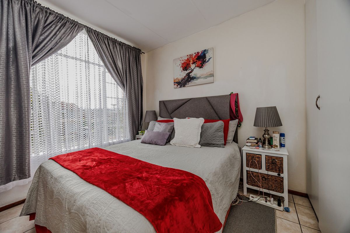 A cozy bedroom featuring tiled flooring and a built-in wardrobe, offering a functional and comfortable living space.