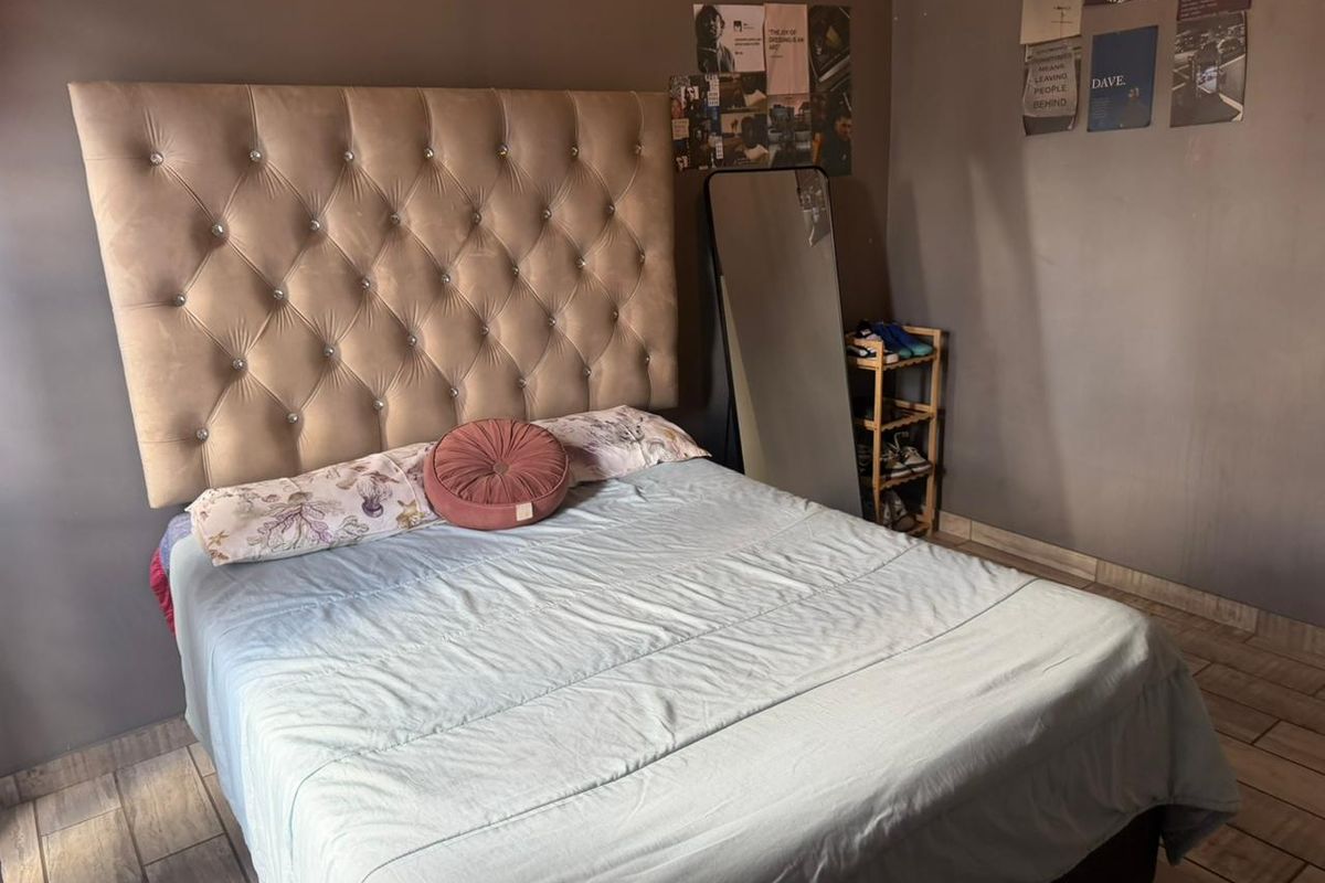 A bedroom featuring tiled flooring and dark painted walls, providing a functional space for rest.