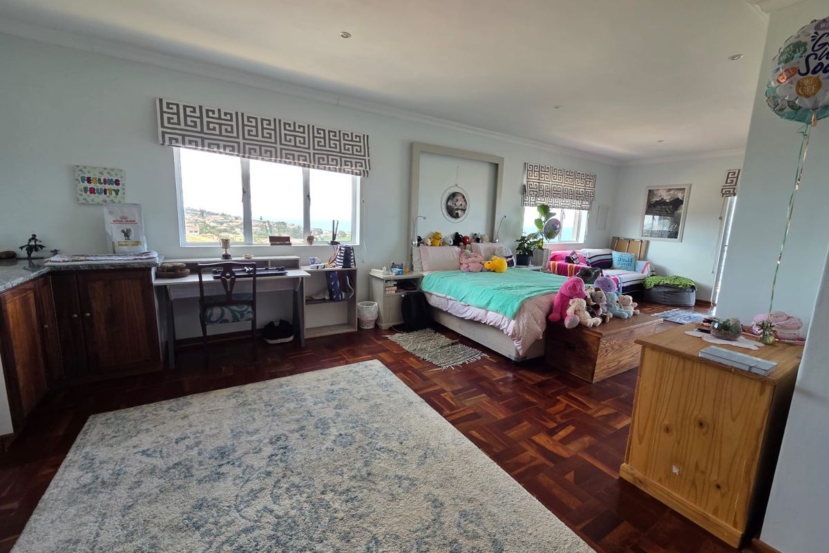 Spacious bedroom featuring warm parquet flooring, recessed lighting, and built-in cabinetry, offering a comfortable living space with natural light.