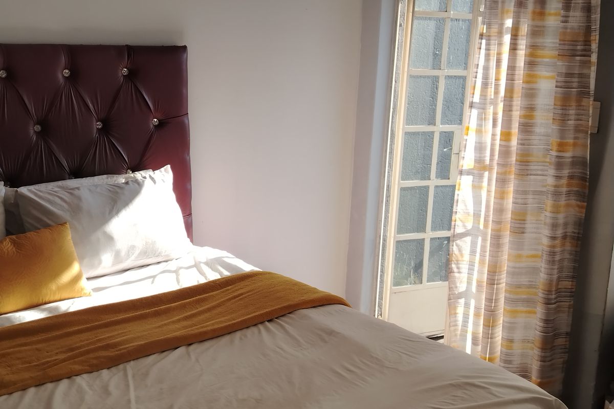 A bedroom featuring a glass-paned door providing natural light and access to an outdoor area.