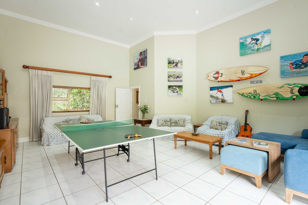 Spacious living area featuring tiled flooring, recessed downlighting, and decorative cornicing, currently utilized as a recreational space.