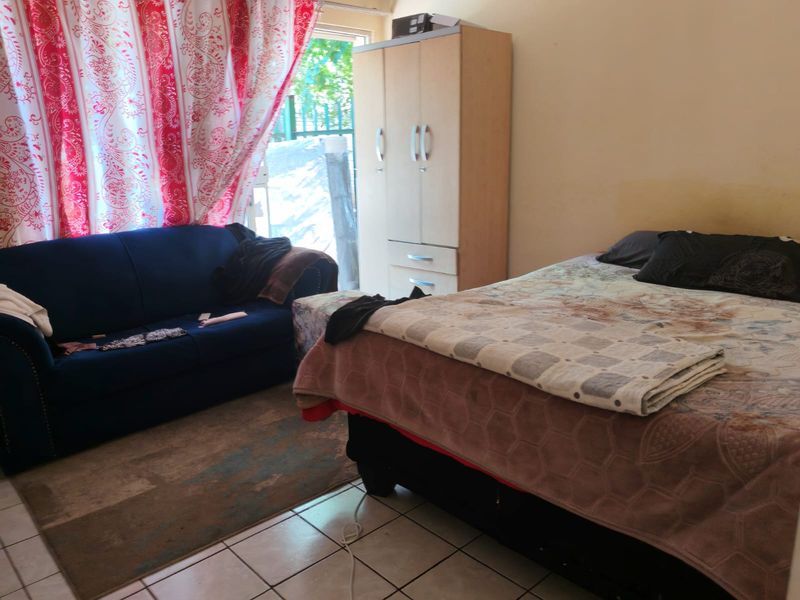 A bedroom featuring tiled flooring and a sliding glass door providing access to the exterior.