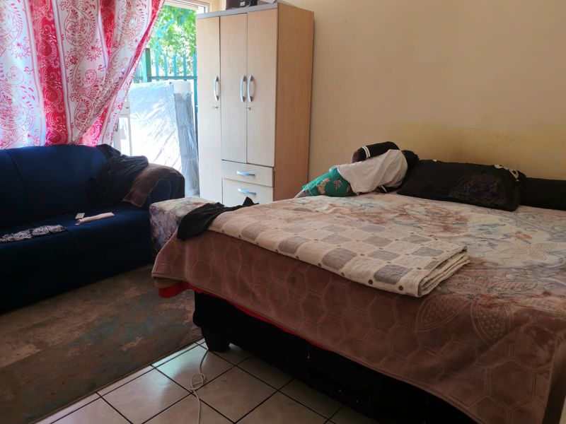 A bedroom featuring tiled flooring and a built-in wardrobe, with direct access to an outdoor area.