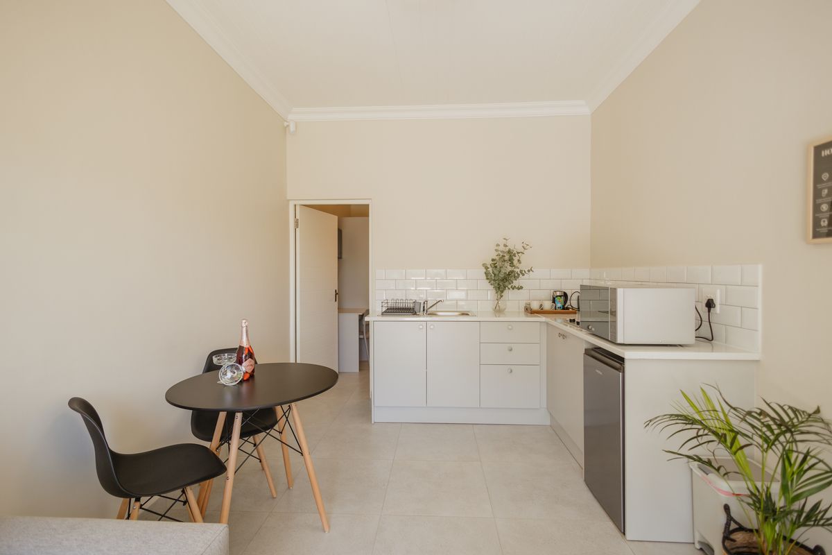 A clean, modern kitchen featuring white cabinetry, a subway tile backsplash, and neutral tiled flooring, providing a functional and bright cooking space.