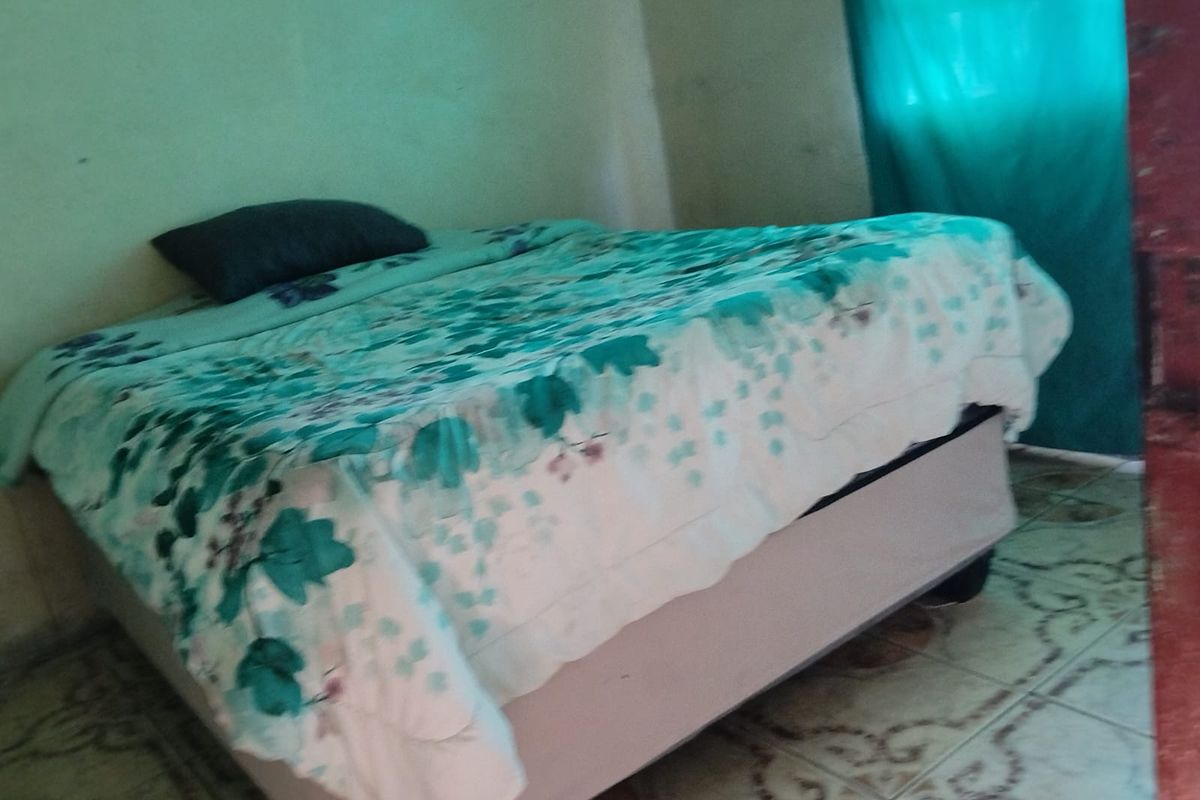 A bedroom featuring tiled flooring and painted walls, currently requiring cosmetic updates to improve the overall condition and aesthetic appeal.
