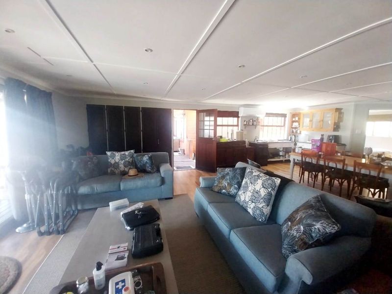 Spacious open-plan living and dining area featuring timber flooring, recessed lighting, and an integrated kitchen space with ample cabinetry.