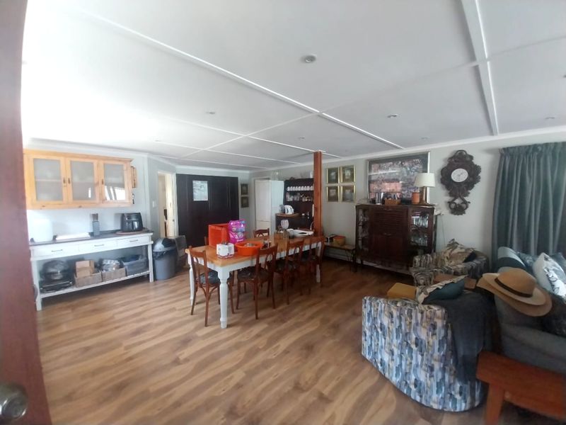 Spacious open-plan living and dining area featuring laminate flooring, recessed ceiling lighting, and built-in cabinetry, offering a versatile layout for family living.