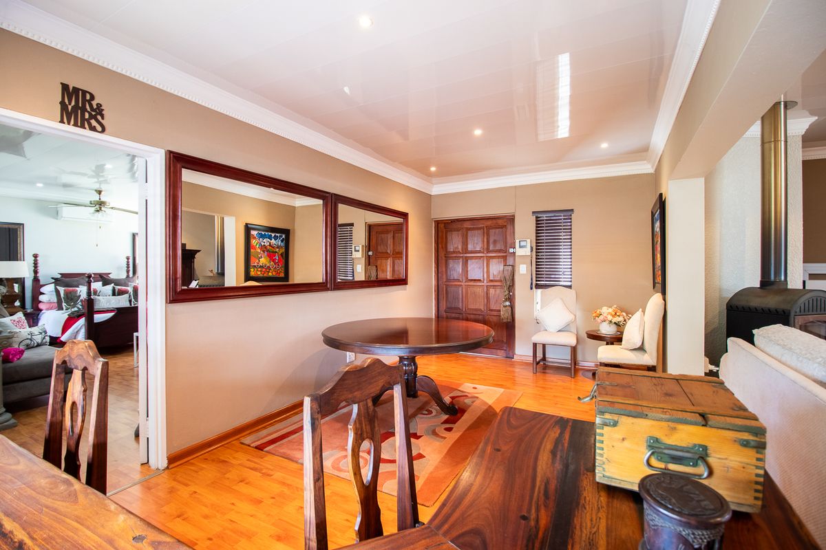 A well-maintained living area featuring warm wood flooring, crown molding, recessed lighting, and a built-in wood-burning fireplace, providing a cozy and inviting atmosphere.