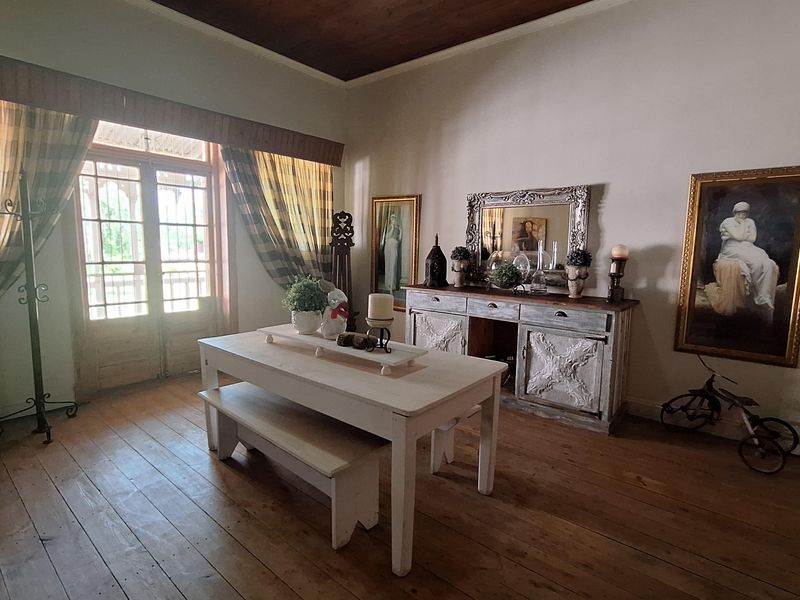 A dining room featuring traditional timber flooring, a vaulted timber ceiling, and double glass doors providing access to the exterior.