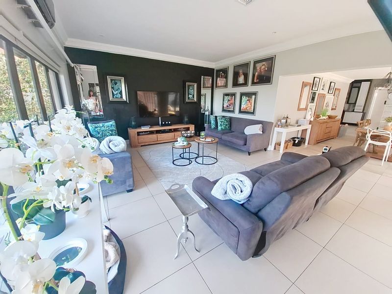 Spacious open-plan living area featuring large format floor tiles, recessed lighting, and sliding glass doors providing ample natural light.