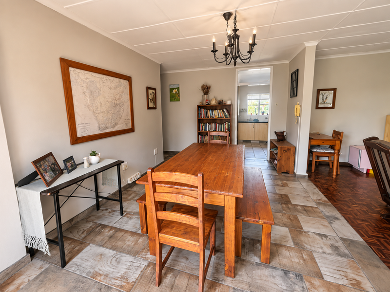Open plan dining area featuring a mix of tiled and parquet flooring, a wrought iron chandelier, and direct access to the kitchen.