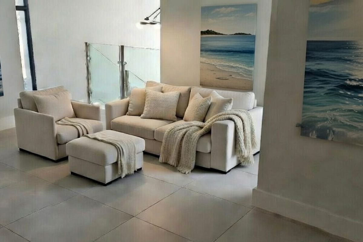 A bright and modern living area featuring large format floor tiles and a contemporary glass balustrade, creating an open and airy atmosphere.