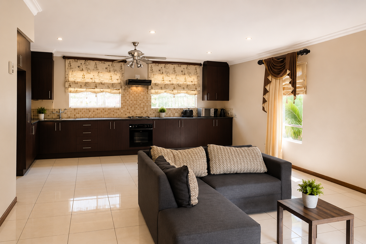 Spacious open-plan kitchen and living area featuring dark wood cabinetry, tiled flooring, recessed lighting, and integrated kitchen appliances.