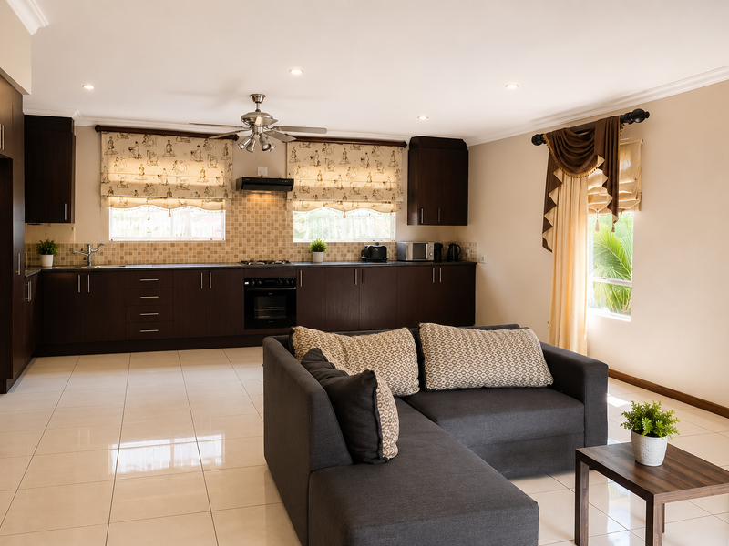 Spacious open-plan kitchen and living area featuring dark wood cabinetry, tiled flooring, recessed lighting, and integrated kitchen appliances.