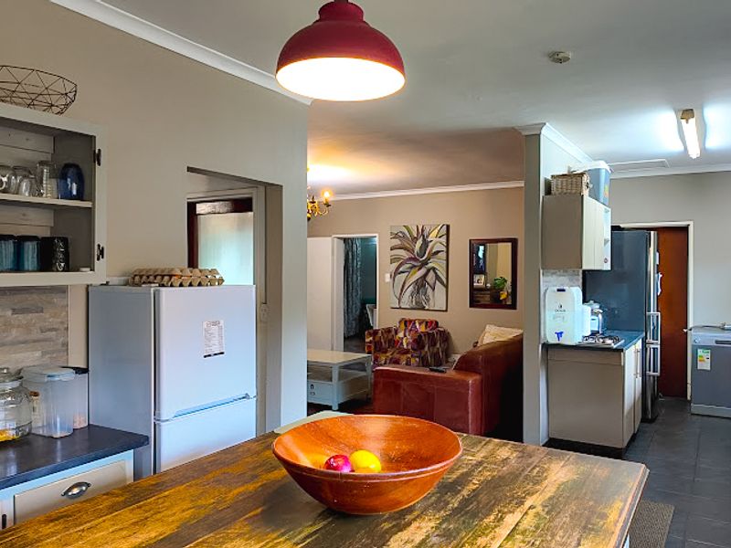An open-plan kitchen and living area featuring tiled flooring, built-in cabinetry, and a central island, creating a functional and connected living space.