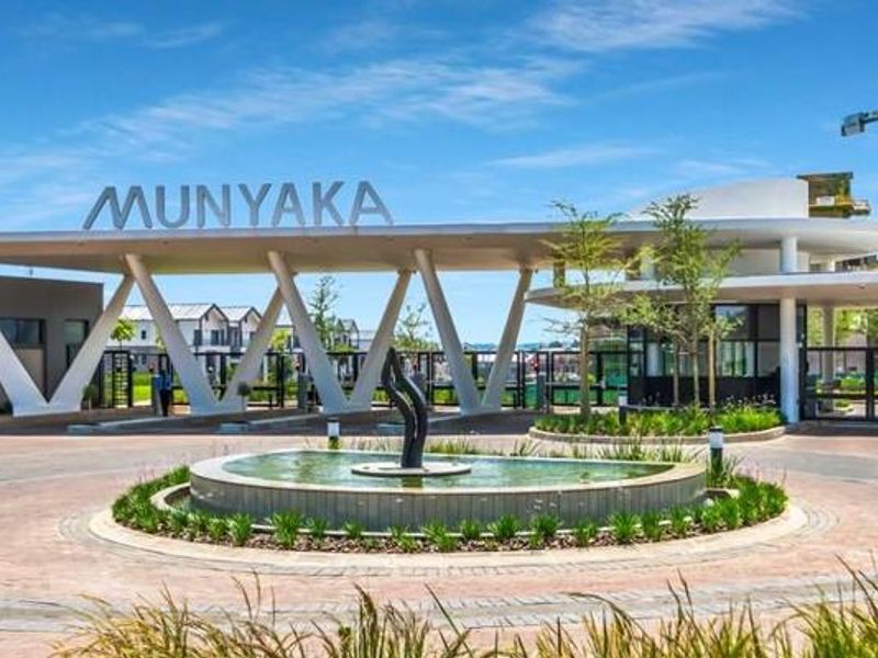 The main entrance gatehouse of the Munyaka estate, featuring a modern architectural design, a central water feature, and well-maintained landscaped surroundings.