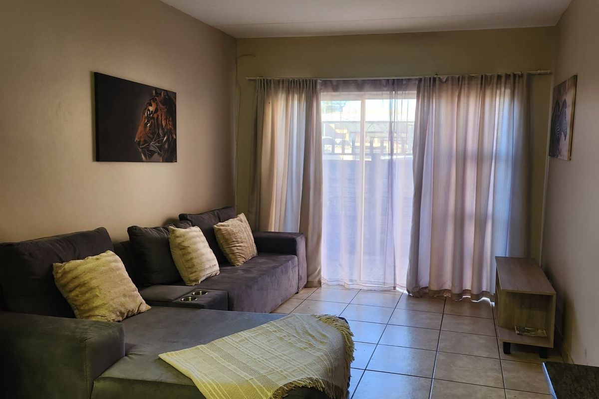 A living room featuring tiled flooring and a sliding glass door providing access to the exterior.