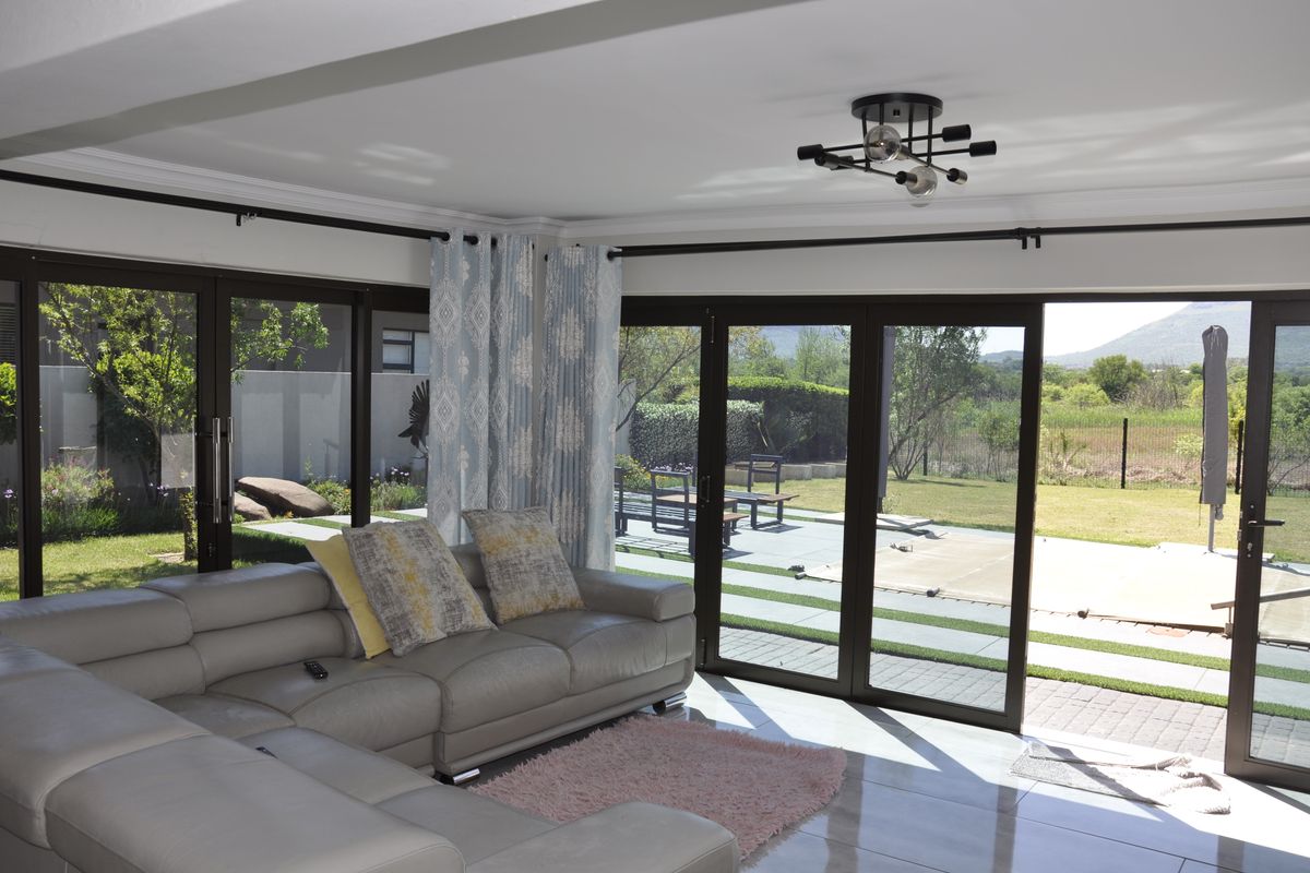 Bright living room featuring large sliding glass doors that provide seamless access to the outdoor patio and garden area.