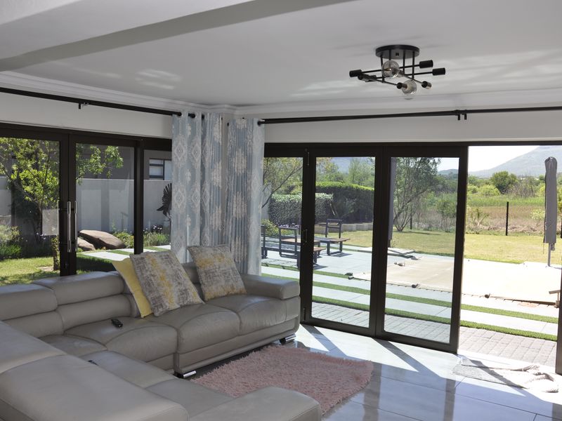 Bright living room featuring large sliding glass doors that provide seamless access to the outdoor patio and garden area.