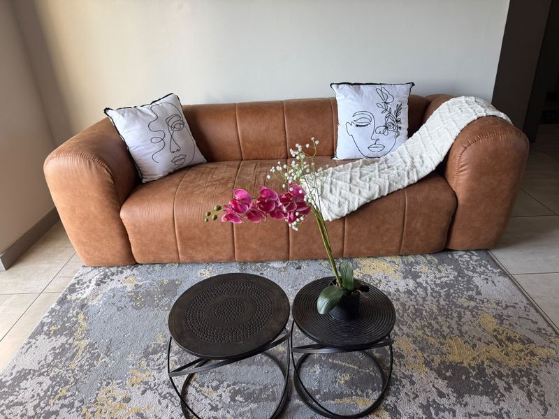 A comfortable living room area featuring tiled flooring and neutral wall finishes, providing a clean and inviting space.