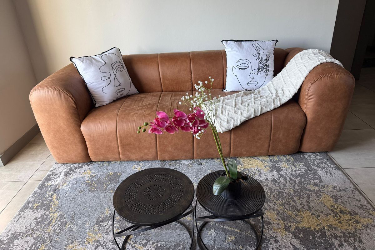 A comfortable living room area featuring tiled flooring and neutral wall finishes, providing a clean and inviting space.